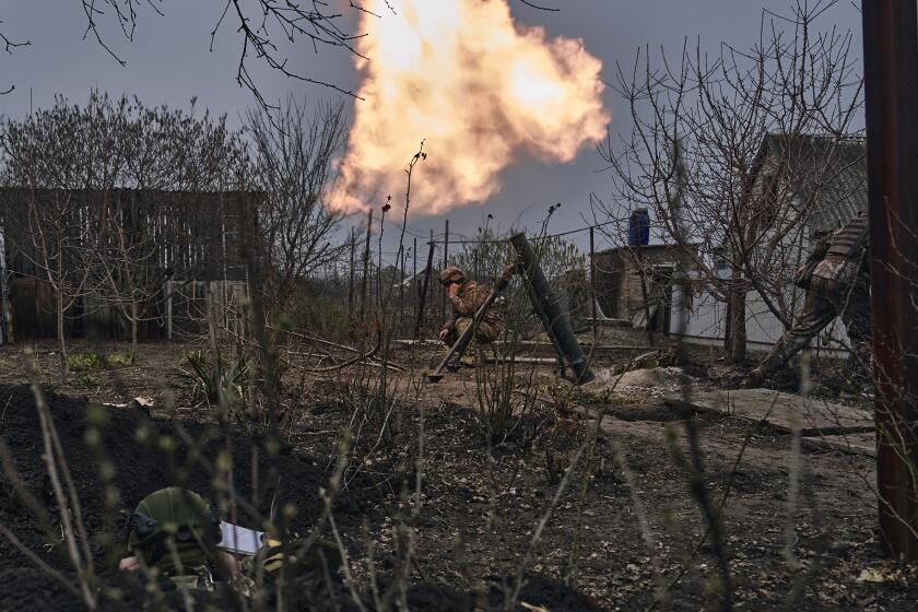 Ukrainian soldiers fire a mortar at Russian positions on the frontline near Bakhmut, Donetsk region, Ukraine, Sunday, March 26, 2023. (AP Photo/Libkos)