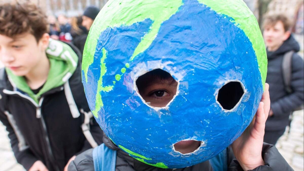 A youth in Berlin wears a mask in the shape of Earth on March 15, 2019, during the Fridays For Future movement's global day of student protests aimed at spurring world leaders into action on climate change.