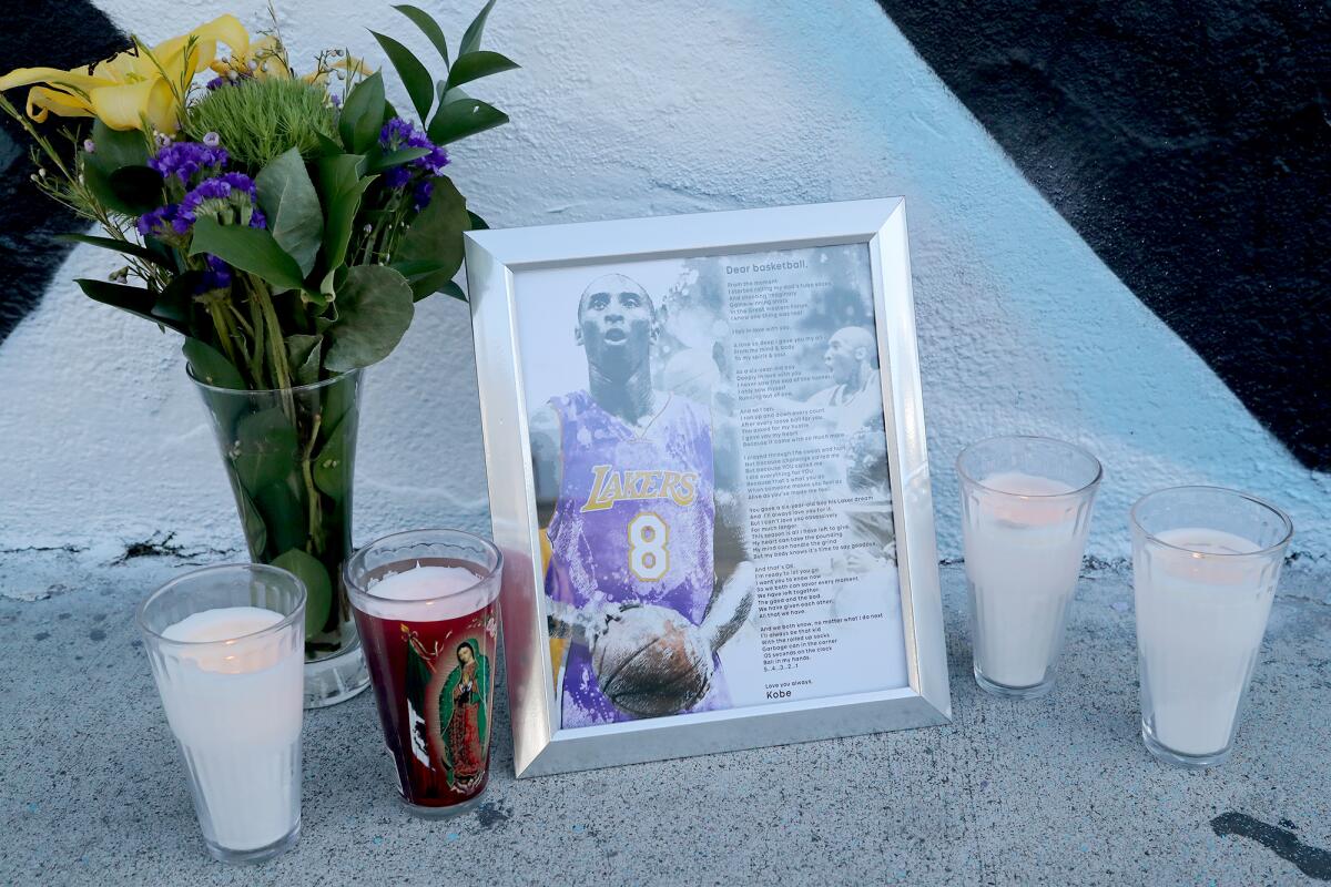 A framed picture of Los Angeles Lakers legend Kobe Bryant, flowers and candles in Costa Mesa on Tuesday.
