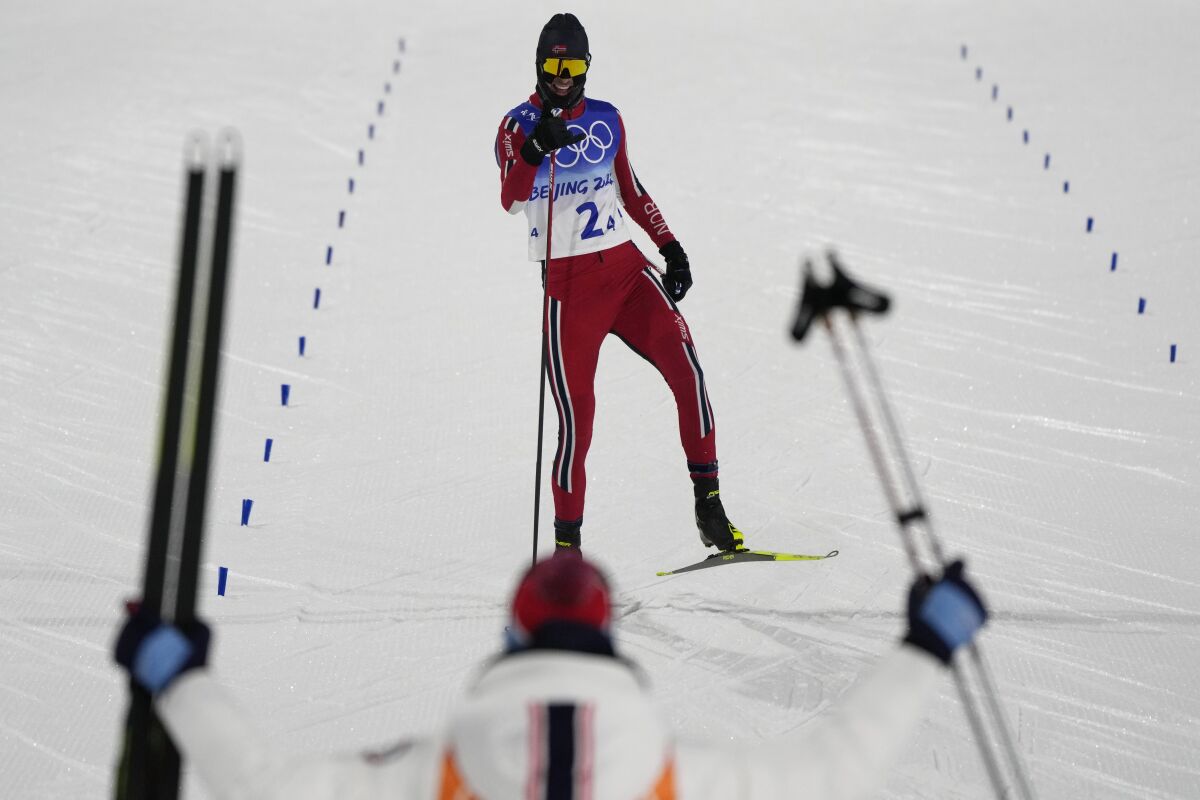Norway's Joergen Graabak celebrates as he nears the finish line during the cross-country skiing competition of the team Gundersen large hill/4x5km at the 2022 Winter Olympics, Thursday, Feb. 17, 2022, in Zhangjiakou, China. (AP Photo/Alessandra Tarantino)