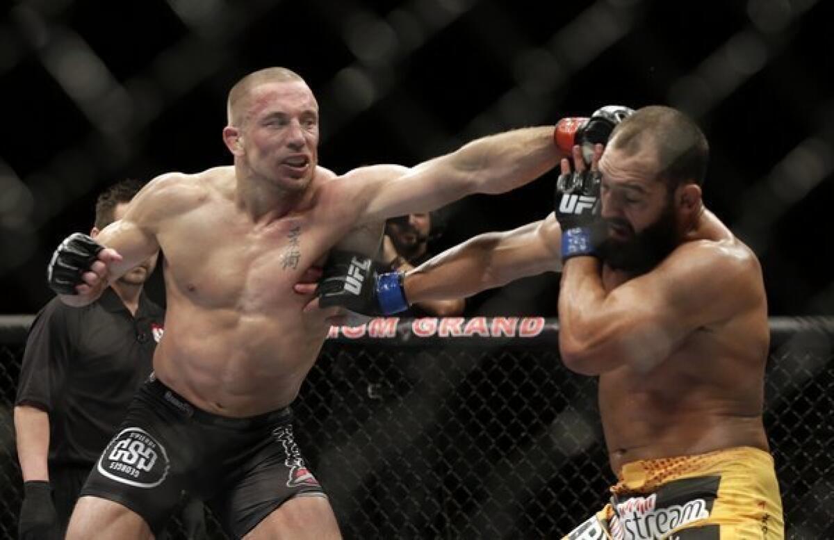 Georges St-Pierre, left, tags Johny Hendricks with a left hand during a welterweight bout Saturday at UFC 167 in Las Vegas.