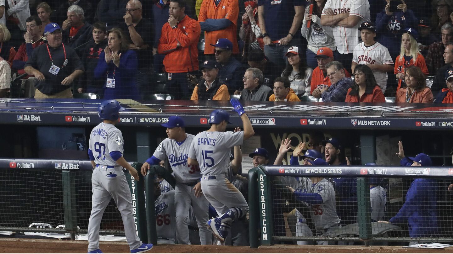 Austin Barnes celebrates with teammates in the Dodgers bullpen after hitting a sacrifice fly for a 3-1 lead in the top of the ninth inning.