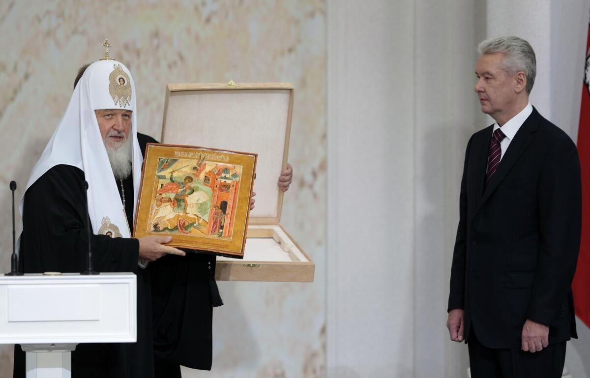 Russian Orthodox Church Patriarch Kirill, left, presents an icon depicting St. George slaying a dragon to Moscow Mayor Sergei Sobyanin at his inauguration Thursday.