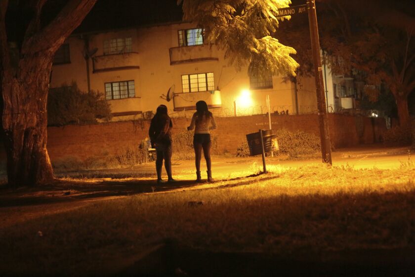 Sex workers wait for clients in the red light district of Harare, Zimbabwe, Friday, June 12, 2020. As the coronavirus spreads in Africa, it increasingly threatens those who earn their living on the streets, including sex workers with HIV. (AP Photo/Tsvangirayi Mukwazhi)