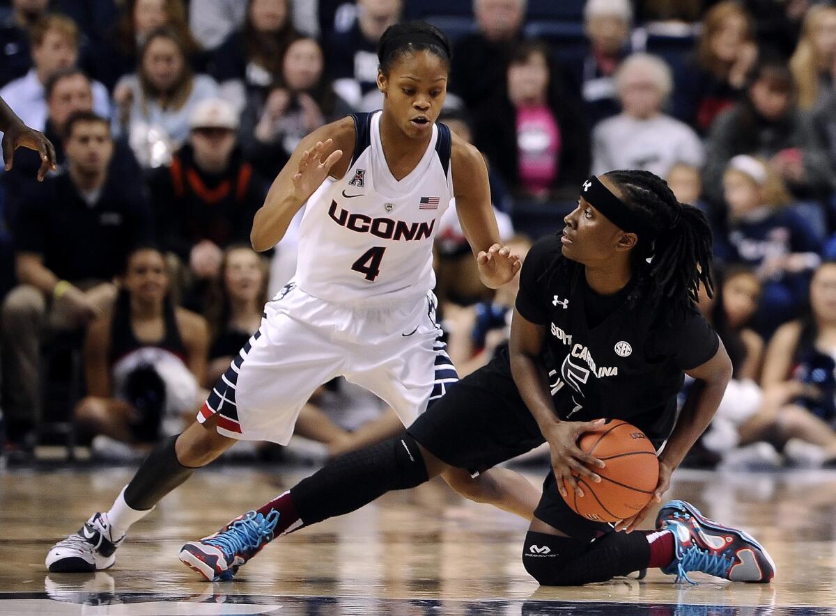 South Carolina guard Khadijah Sessions looks to pass around Connecticut guard Moriah Jefferson from her knee.