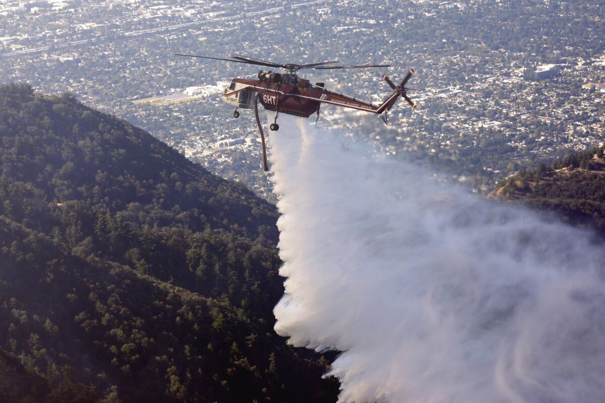 A helicopter makes a water drop on a fire near the Mt. Wilson Observatory.