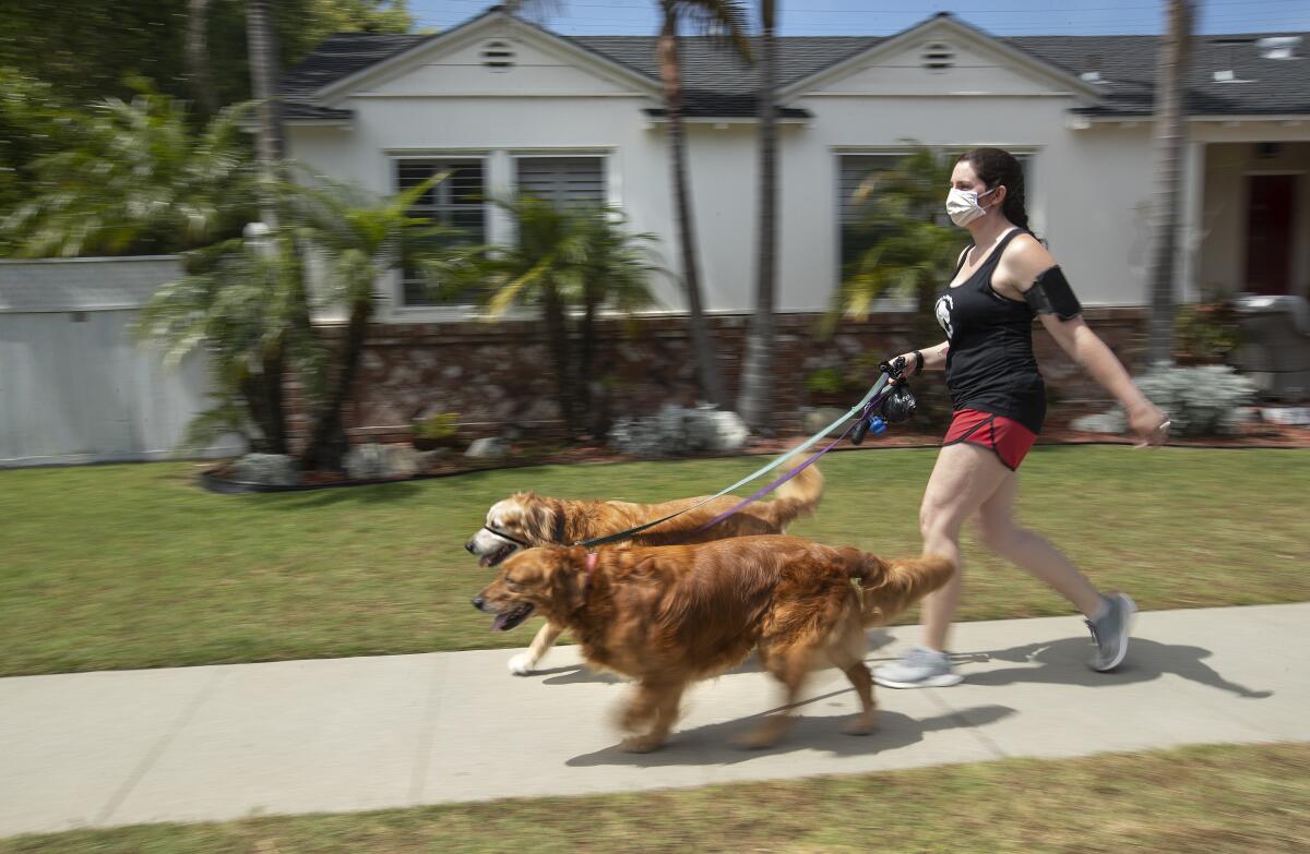 Lindsay Rojas, 28, walks two golden retrievers in Culver City.