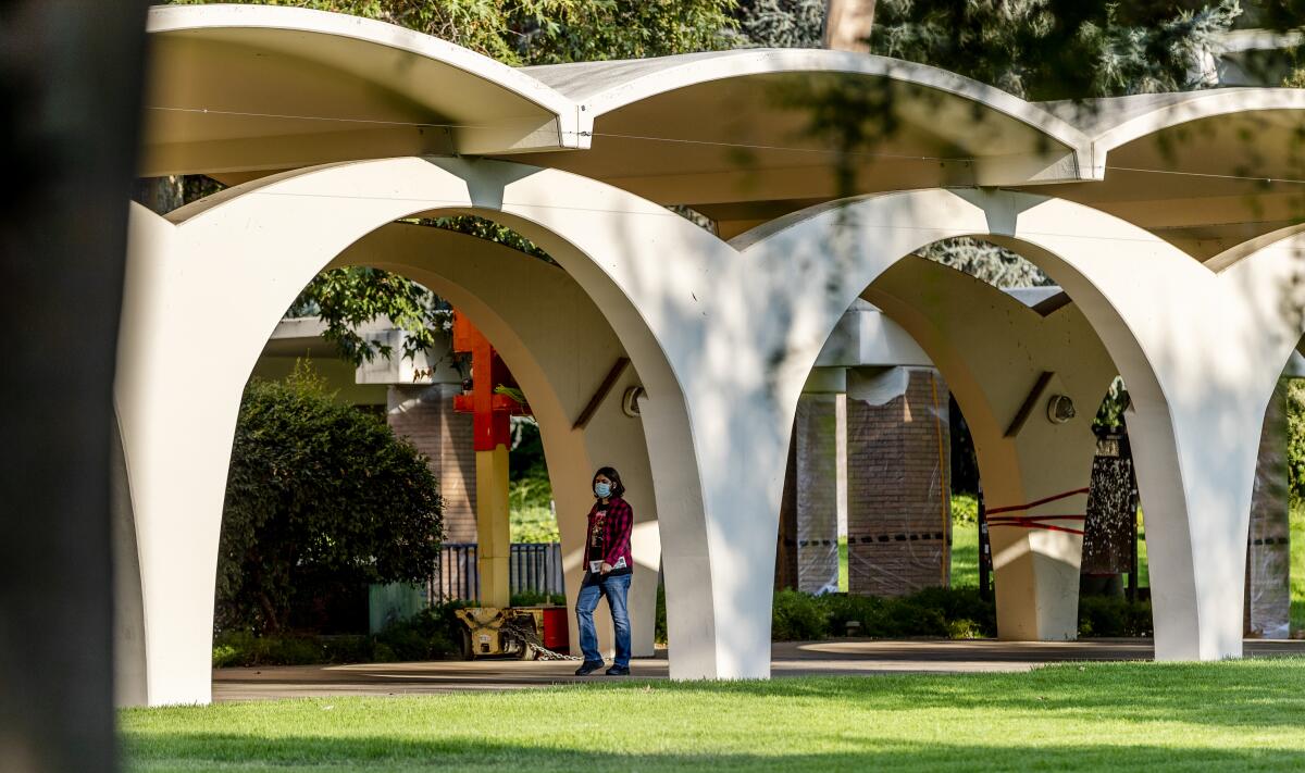 A masked student walks on the main UC Riverside campus in July. 