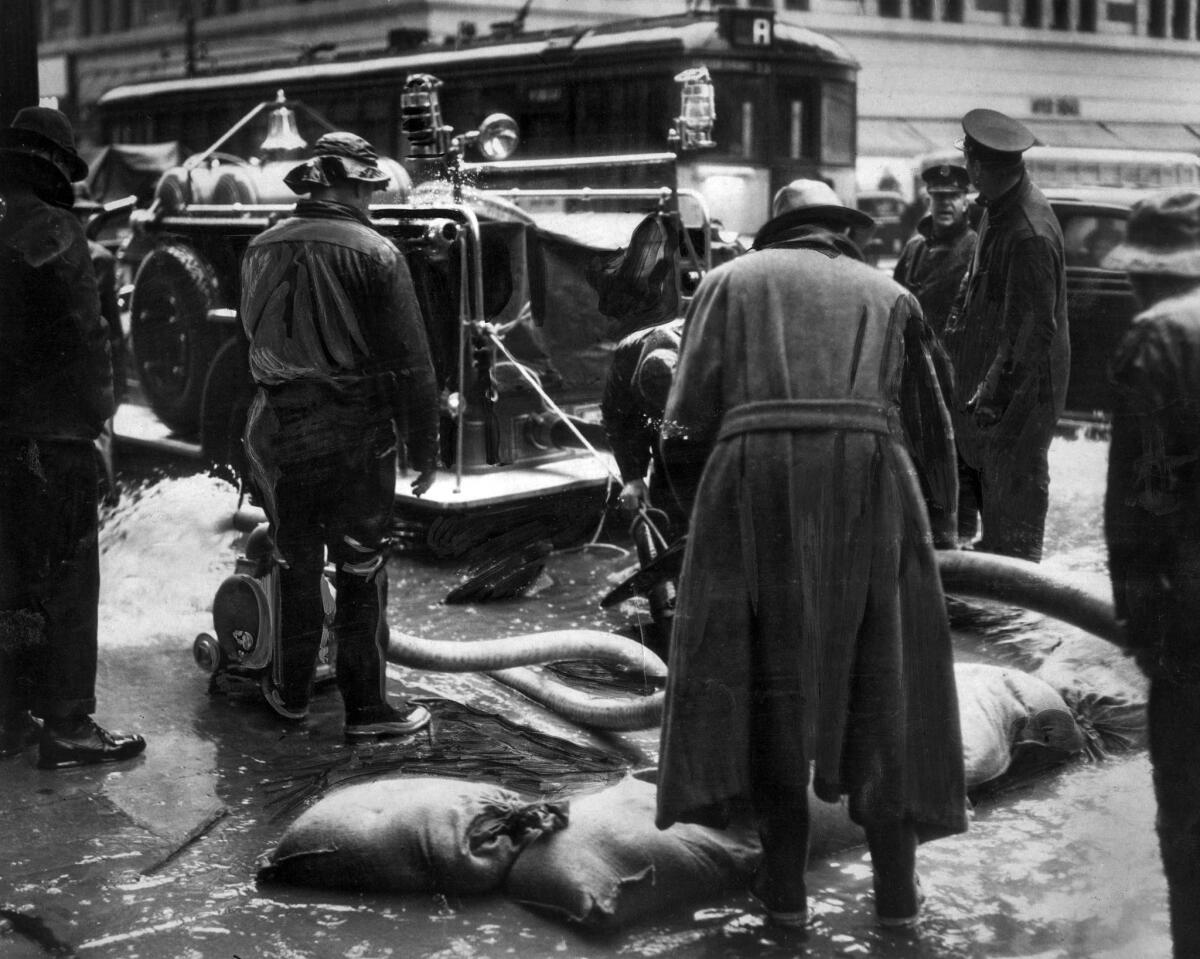 March 2, 1938: Fire department pumping engines remove water from underground conduits carrying telephone cables in downtown Los Angeles.
