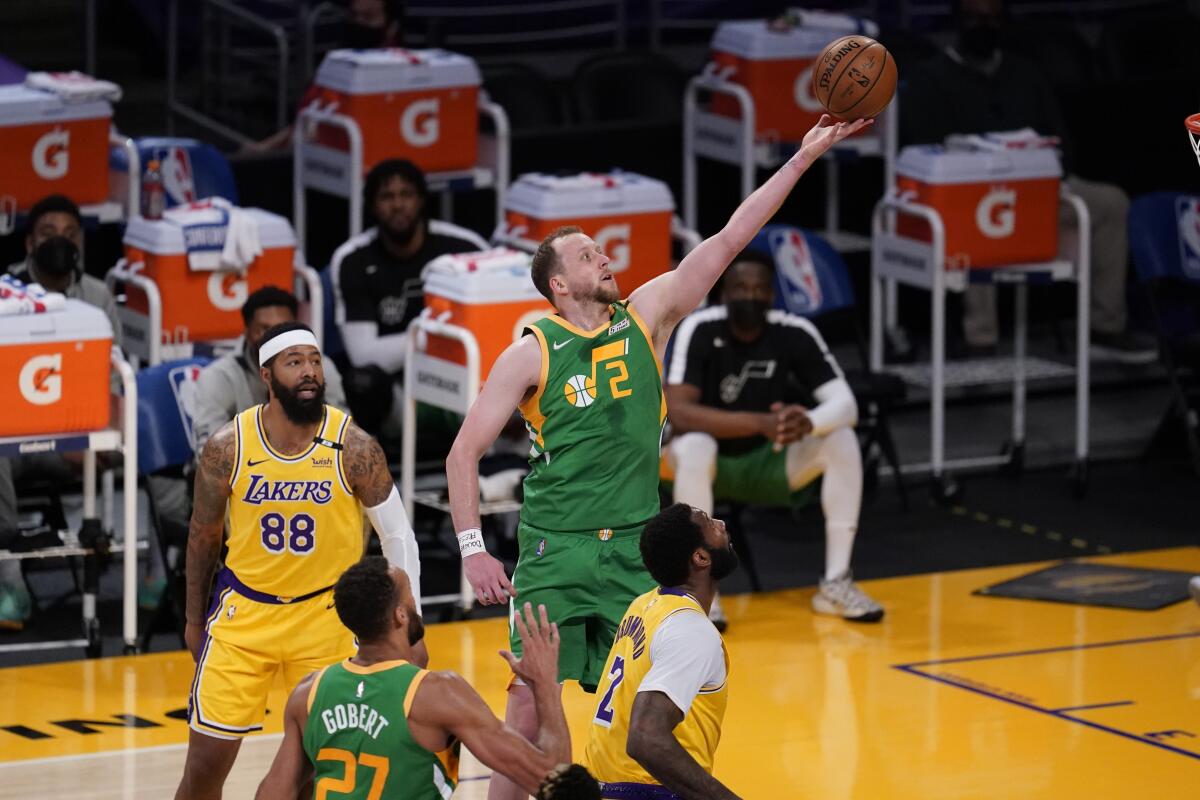 Utah's Joe Ingles scores on a layup over Lakers forward Markieff Morris and Andre Drummond.