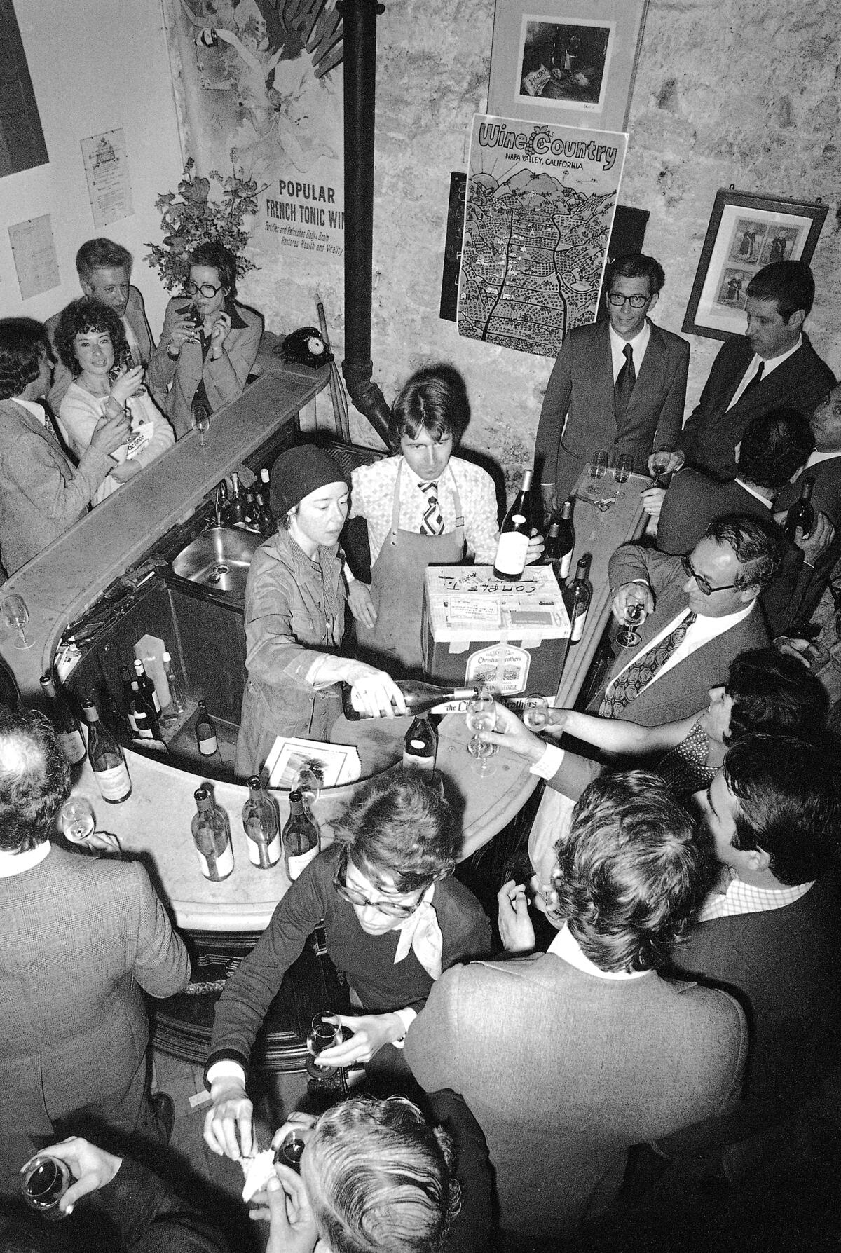 Steven Spurrier serves guests at a wine tasting in Paris in 1975.  