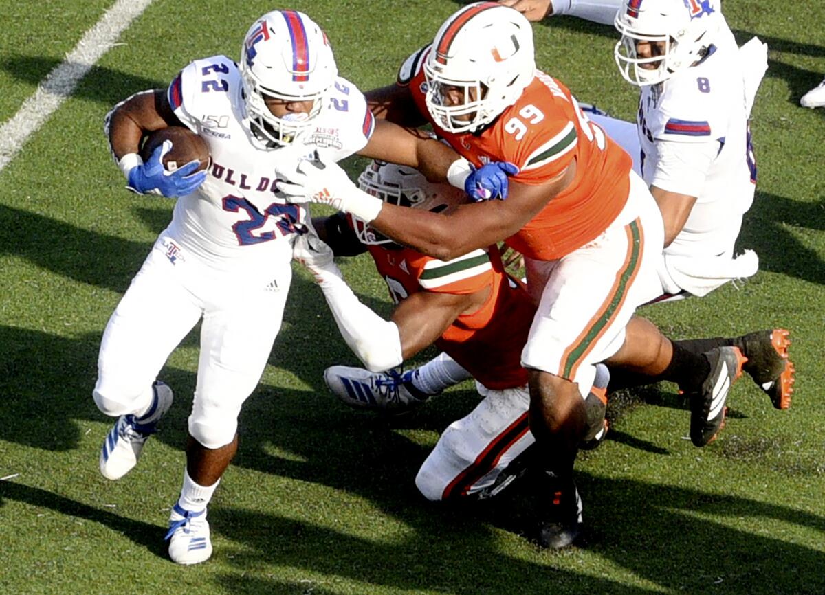 Louisiana Tech's Israel Tucker, left, runs with the ball during the game against Miami during the first half of the Independence Bowl on Thursday in Shreveport, La.