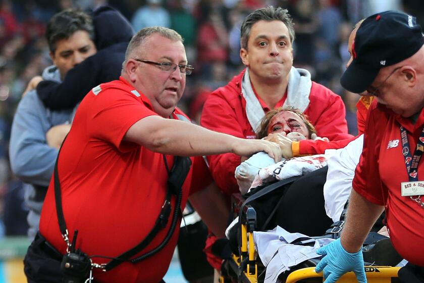 A fan who was seriously injured when she was struck by a broken bat is taken out of Fenway Park on Friday night.