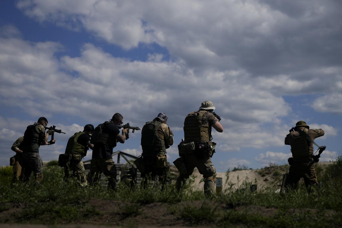 Soldiers hold up shotguns.