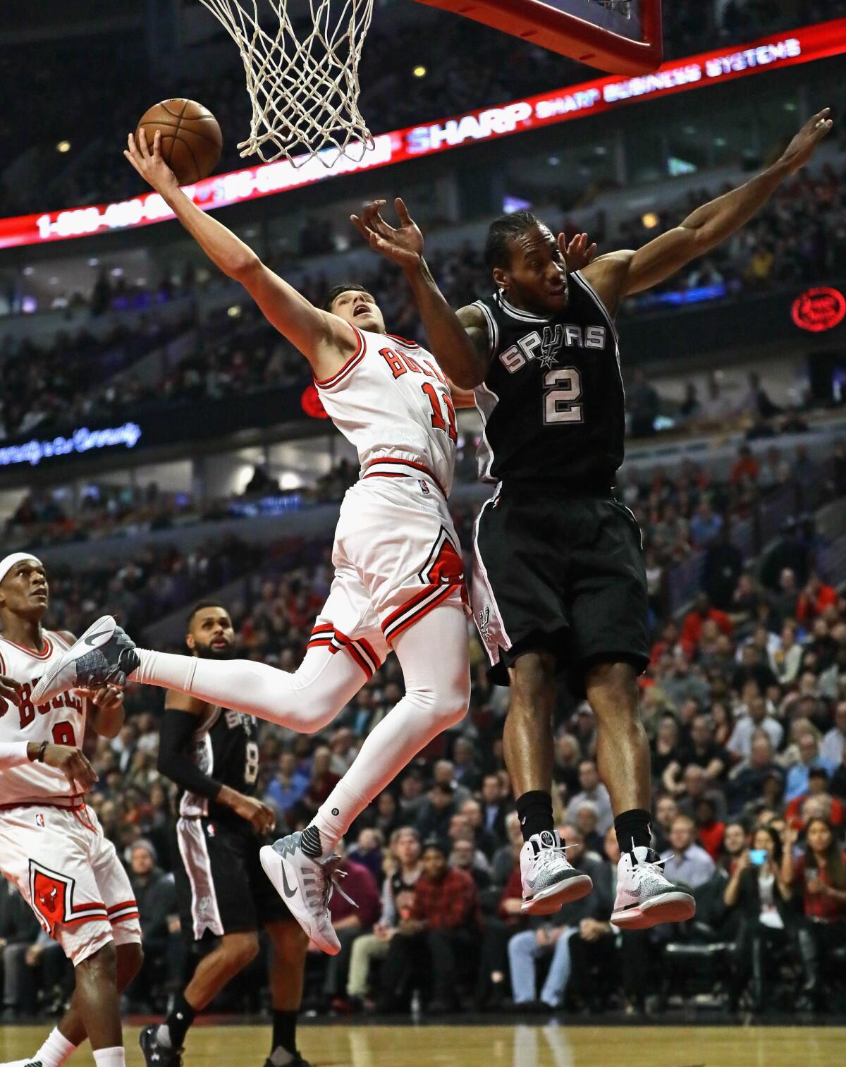 Doug McDermott, de los Bulls de Chicago lanza ante Kawhi Leonard, de los Spurs de San Antonio el pasado jueves 8 de diciembre en Chicago.