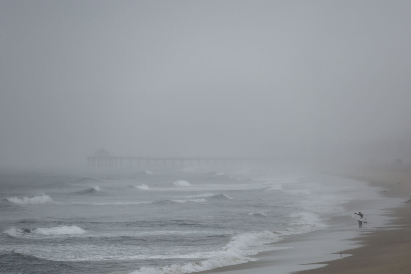 With the Manhattan Beach Pier in the distance, surfers scan the waves of Hermosa Beach.
