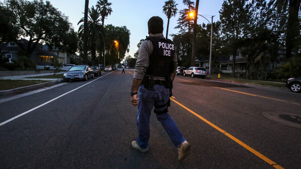 Jorge Field of ICE Enforcement and Removal Operations makes his way to an Aug. 12 raid in Riverside. On Monday, authorities said more than 240 people across Southern California were taken into federal custody last week after a four-day sweep for immigrants with criminal records in the country illegally.