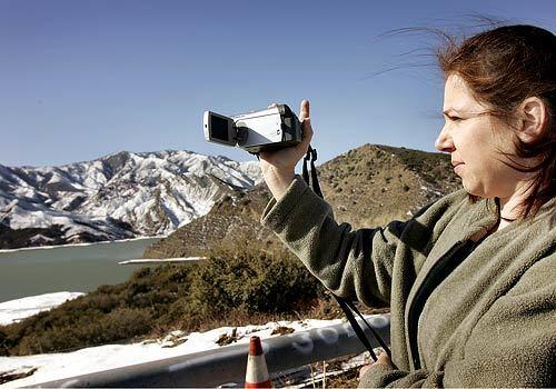 Beatrice Herrera takes video of the snow-covered mountains at Pyramid Lake. She and her family are traveling North on I-5 trying to return to their home in Santa Rose after a vacation to Mexico. Earlier the I-5 Freeway was closed due to snow and ice on the roadway at higher elevations.
