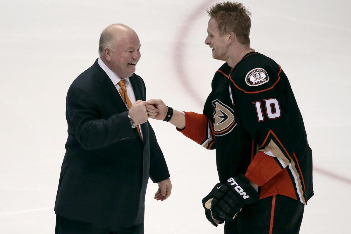 Ducks Coach Bruce Boudreau and right wing Corey Perry share a fist-bump after his game-winning goal in overtime against the Flames.