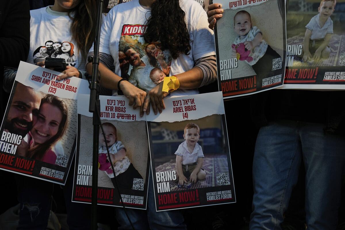 People hold fliers with images of a couple and their children, calling for their release