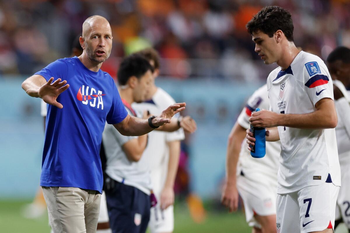 U.S. coach Gregg Berhalter, left, speaks to Gio Reyna during a loss to the Netherlands.