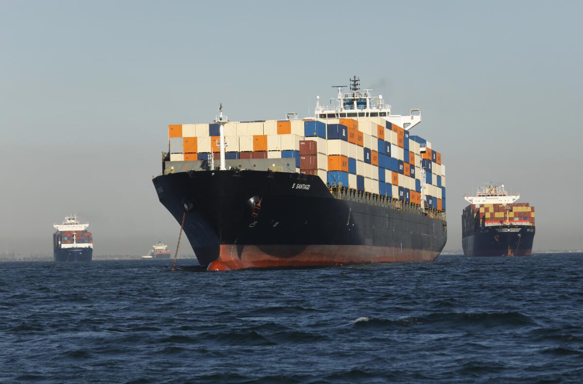 Container ships sit in the ocean near one another