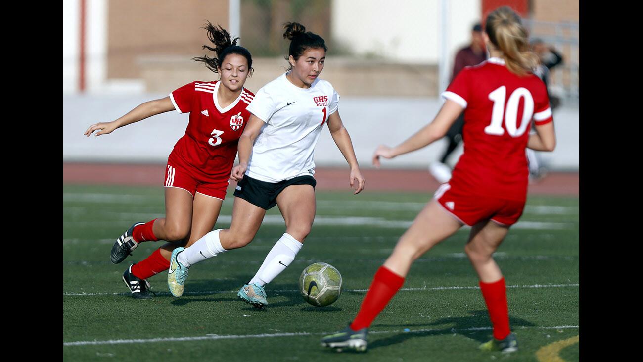 Glendale High School player #1 Ella Wasson weaves her way through defenders #3 Trinity Vournas, left, and #10 Abbie Riggs in home game vs. Burroughs High School, at the Nitros home field in Glendale on Friday, Jan. 5, 2018.