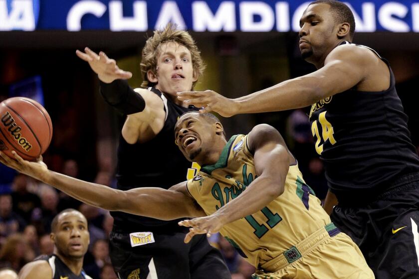 Notre Dame guard Demetrius Jackson attempts a layup against the defense of Wichita State guard Evan Wessel, left, and forward Shaquille Morris (24) during the second half of the Irish's 81-70 victory in a Midwest Regional semifinal Thursday night.