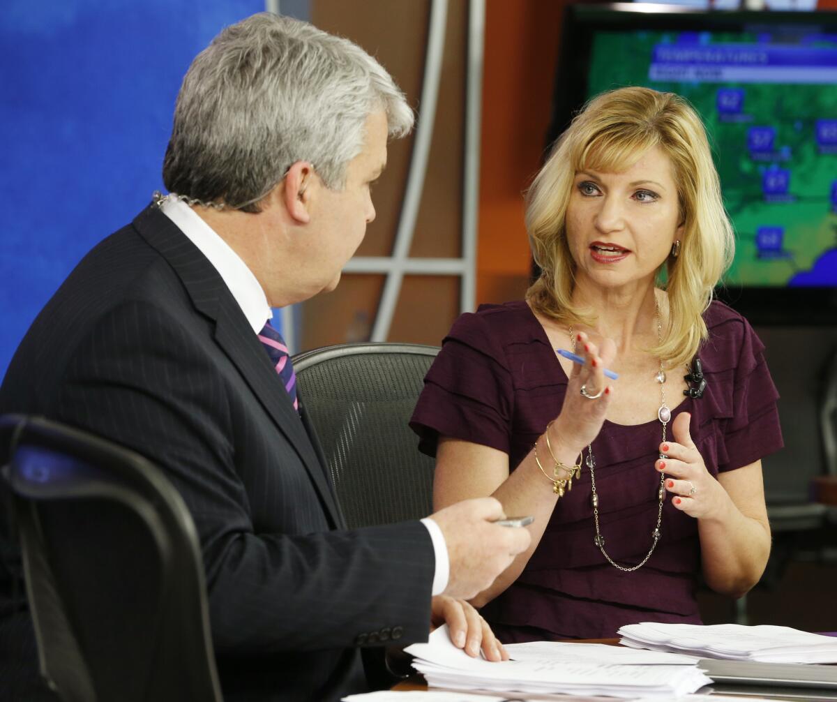 WDBJ-TV anchor Kimberly McBroom talks with guest anchor Steve Grant during the station's early morning newscast in Roanoke, Va., the day after a pair of colleagues were shot to death while on the air.