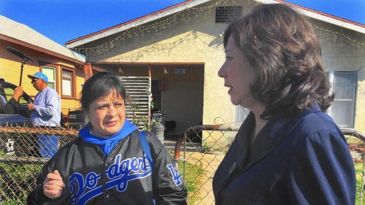 Amelia Vallejo habla con la supervisora del condado de Los Ángeles, Hilda Solís, acerca de la contaminación por plomo hallada en su jardín.