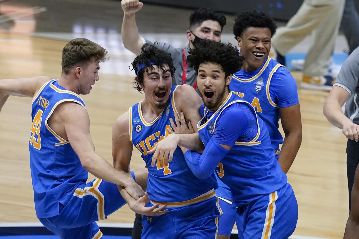 UCLA players celebrate after an Elite 8 game against Michigan in the NCAA men's college basketball tournament.