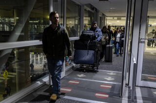 Spencer Sullivan, left, guides Abdulhaq Sodais to a parking garage at O'Hare International Airport in Chicago on Dec. 17.