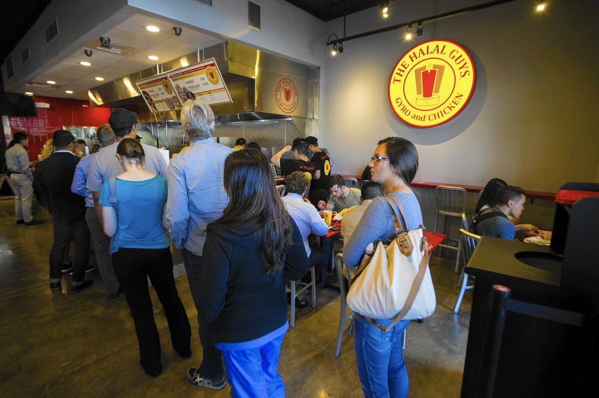 Customers wait in line for lunch at the Halal Guys in Costa Mesa on Oct. 20.