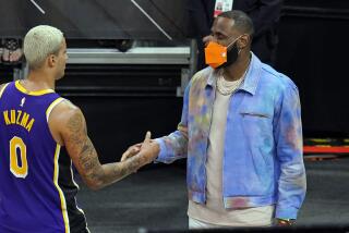 Los Angeles Lakers forward LeBron James, right, greets teammate forward Kyle Kuzma.