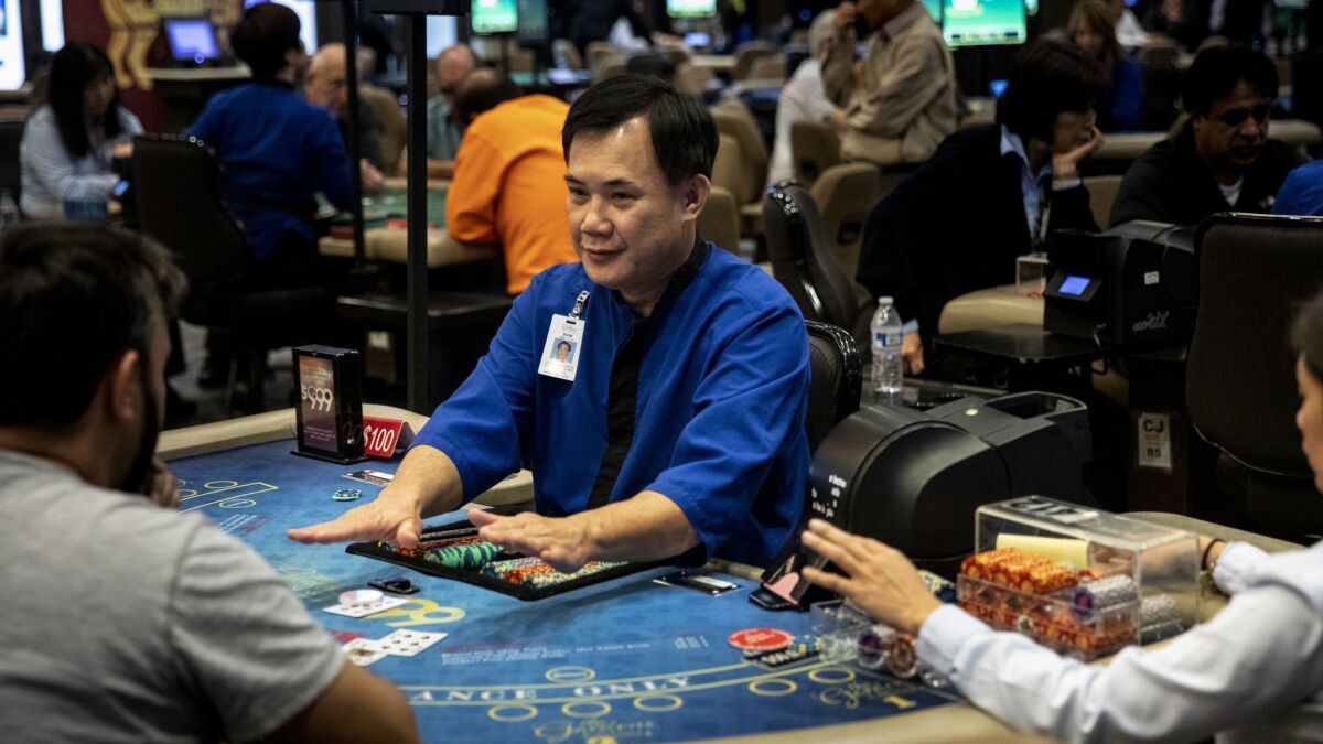 La Nam deals blackjack poker at the Gardens Casino in Hawaiian Gardens on Nov 27. State regulators are considering adopting new regulations for the third-party banker, seated left of Nam. The players bet against the banker not the dealer.