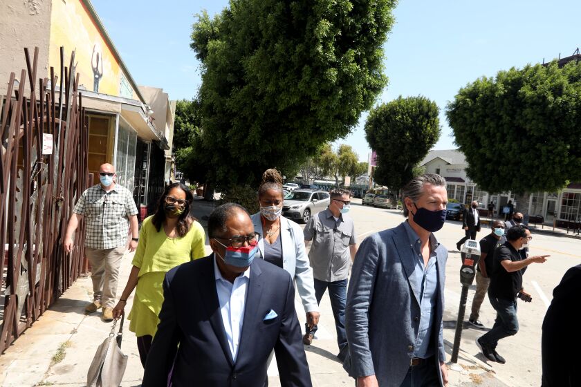 LOS ANGELES, CA - JUNE 03, 2020 - - California Governor Gavin Newsom, right, takes a tour of businesses in Leimert Park with Los Angeles Supervisor Mark Ridley- Thomas,. California Assembly Member Sydney Kamlager-Dove, second from left, and California Senator Holly Mitchell, fourth from left, after days of protests in Los Angeles in Leimert Park in Los Angeles on June 3, 2020. (Genaro Molina / Los Angeles Times / POOL)