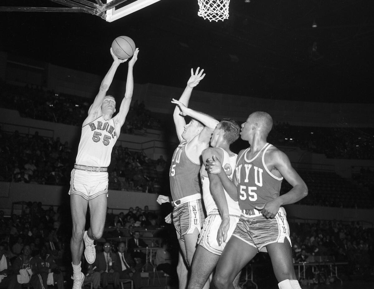 UCLA's Gary Cunningham, left, shoots during a game against NYU.