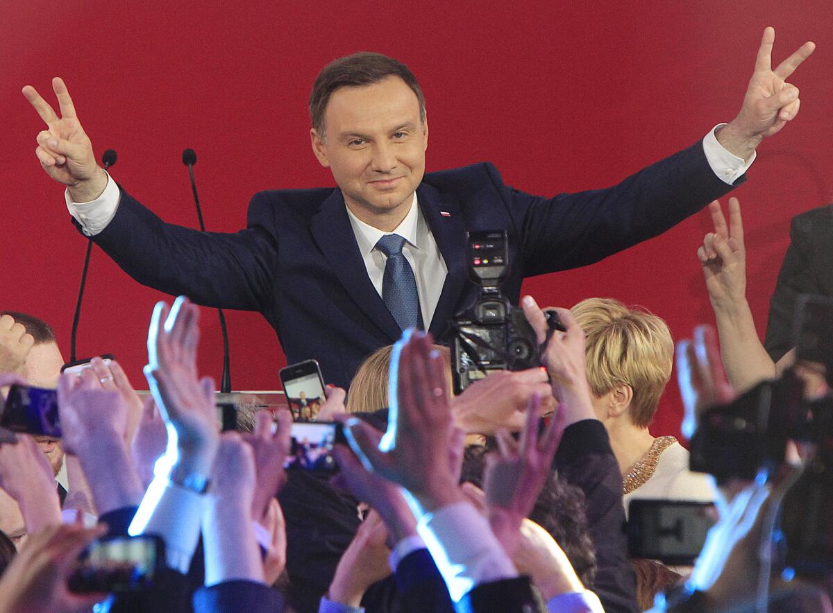 Opposition candidate Andrzej Duda celebrates with supporters his victory as first exit polls in the presidential runoff voting are announced in Warsaw on May 24.