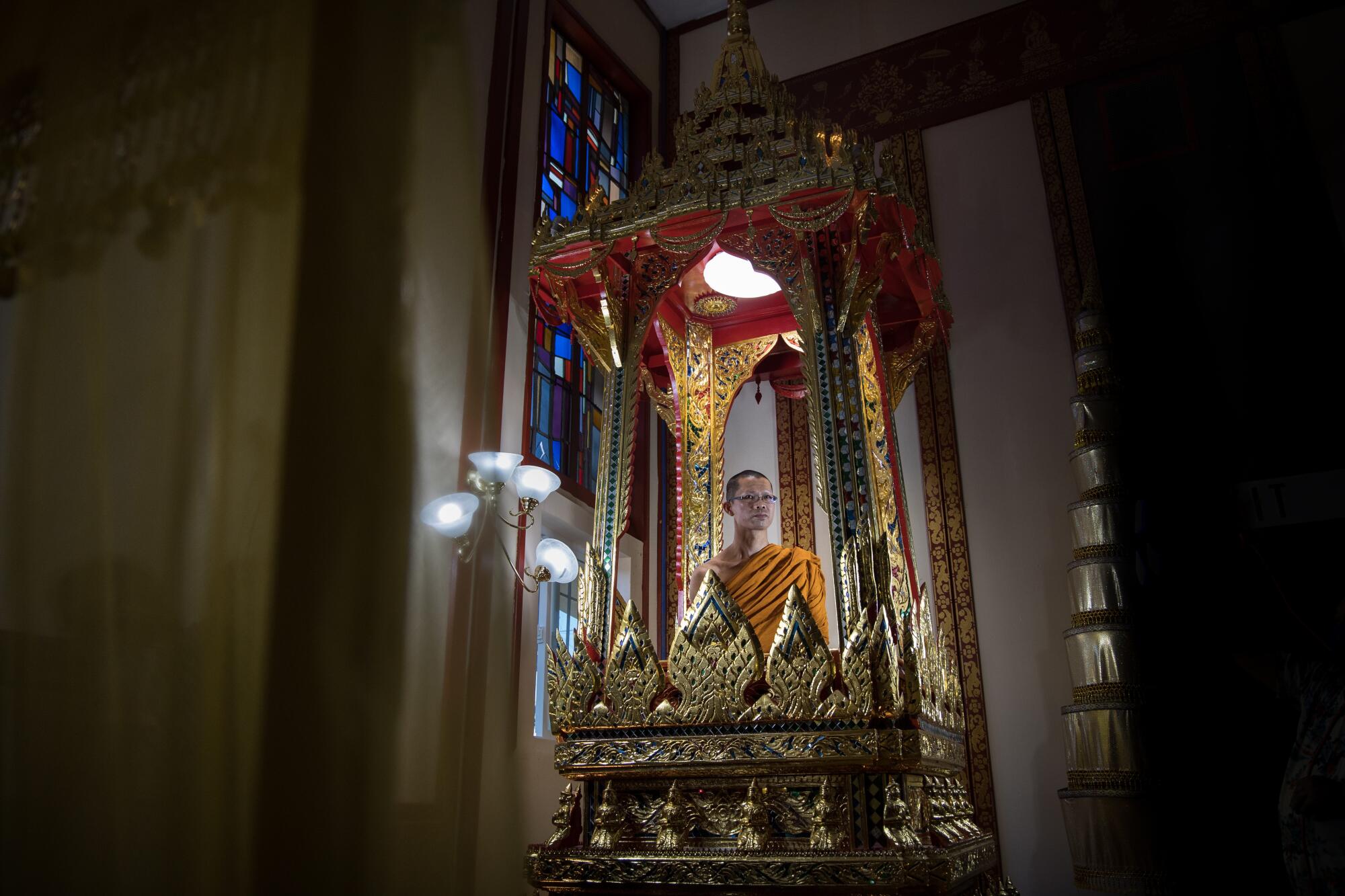 Head Buddhist monk Phra Bouaban Chittapangna sits in a busabok