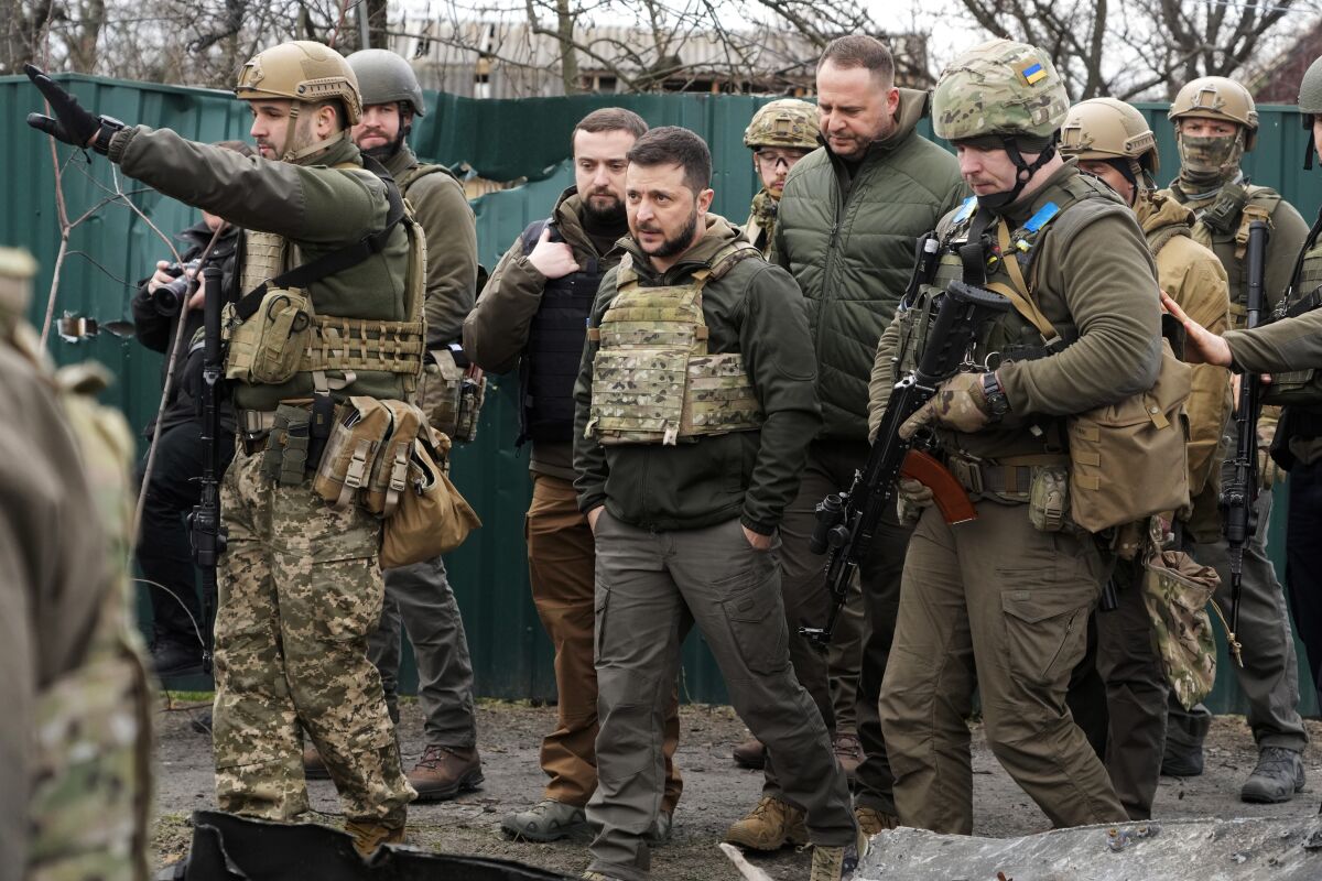 Ukrainian President Volodymyr Zelenskyy examines the site of a recent battle in Bucha close to Kyiv, Ukraine, Monday, April 4, 2022. (AP Photo/Efrem Lukatsky)