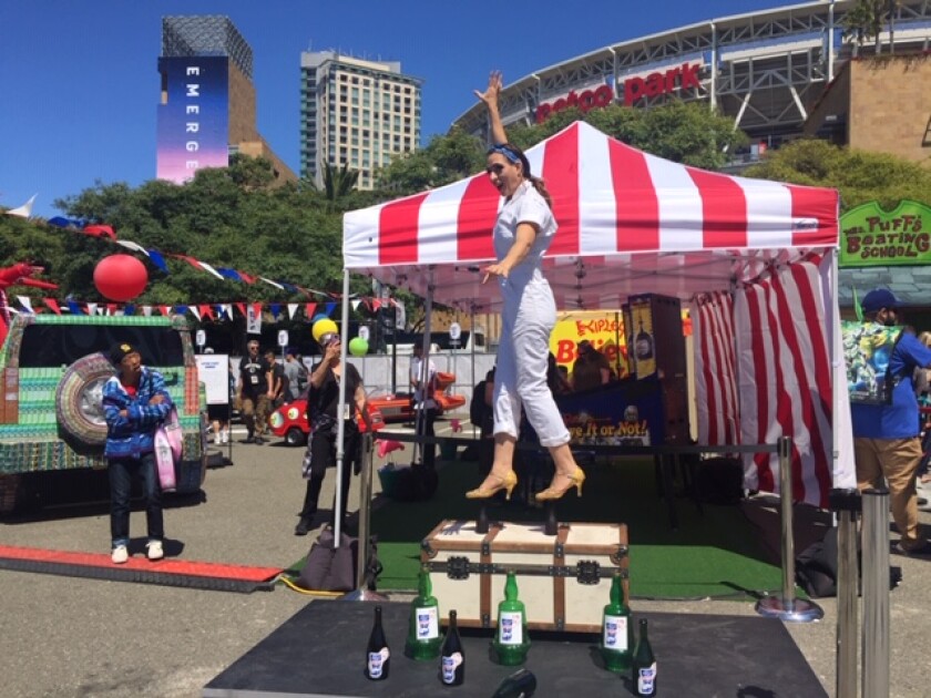 An acrobat from Ripley's Believe it or Not! balances her body weight on the heads of two bottles Friday morning at the Petco Park Interactive Zone