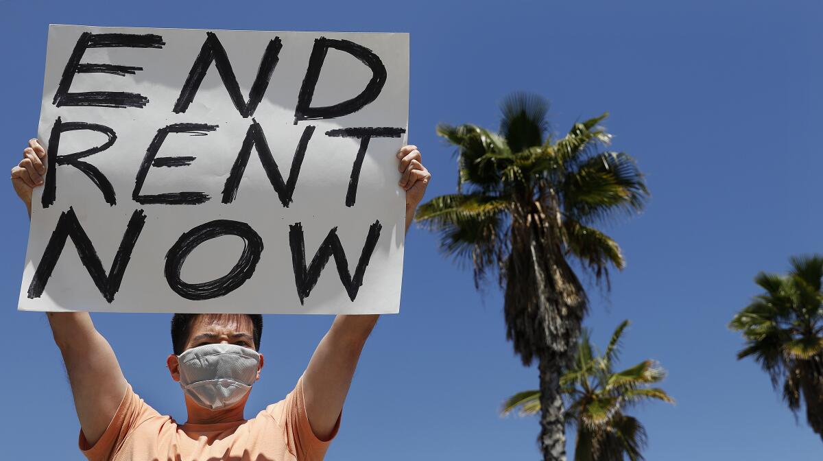 A man holds a sign during a demonstration by the Los Angeles Tenants Union.