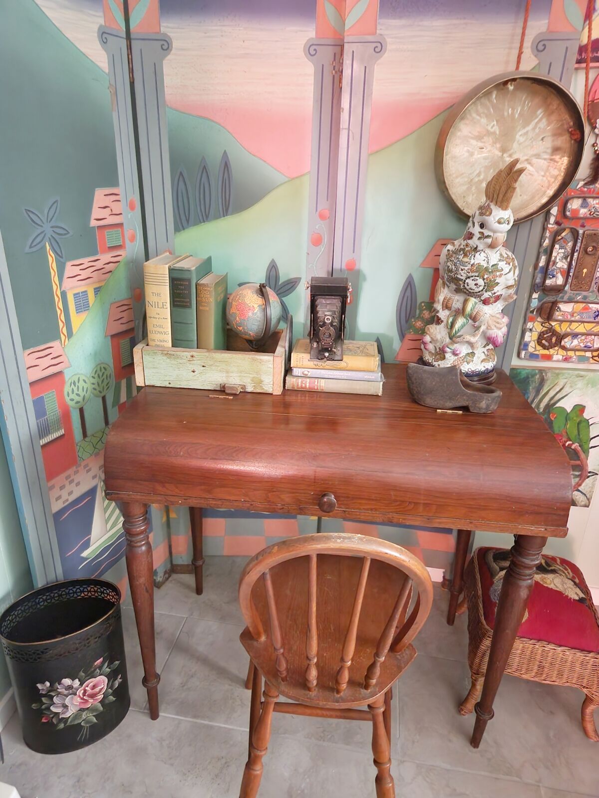 A desk and chair, books, folding screen and more vintage finds share the corner of a room with parrots.