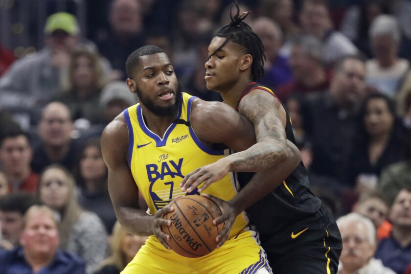 Golden State Warriors' Eric Paschall, left drives past Cleveland Cavaliers' Kevin Porter Jr. in the first half of an NBA basketball game, Saturday, Feb. 1, 2020, in Cleveland. (AP Photo/Tony Dejak)
