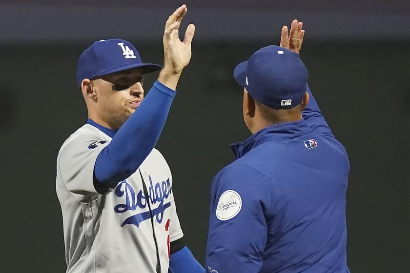 Los Angeles Dodgers' Trayce Thompson, left, celebrates with manager Dave Roberts.