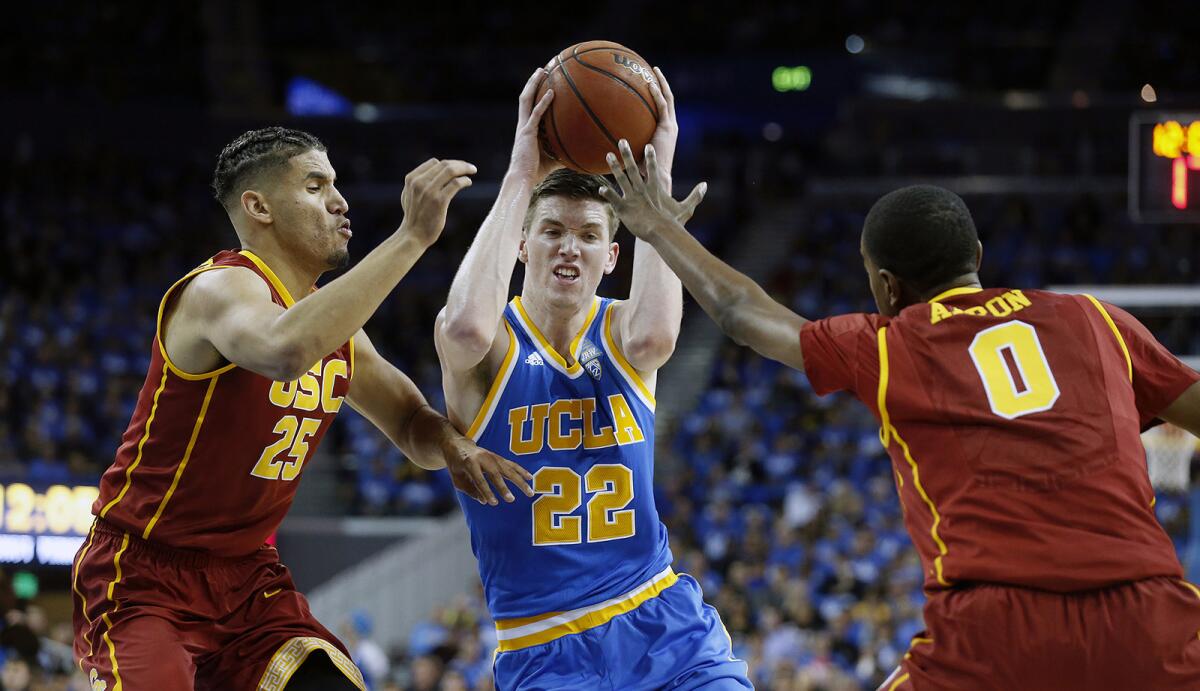 UCLA forward TJ Leaf (22) drives to the basket guarded by USC forward Bennie Boatwright (25) and guard Shaqquan Aaron in the first half of the Bruins' 102-70 win at Pauley Pavilion on Feb.18.