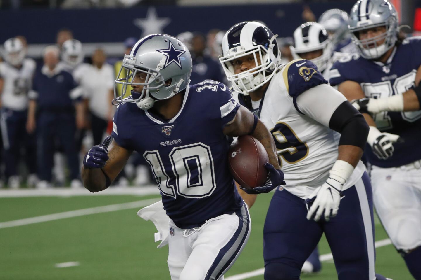Dallas Cowboys wide receiver Tavon Austin (10) carries the ball past Los Angeles Rams defensive tackle Aaron Donald, front right, in the first half of an NFL football game in Arlington, Texas, Sunday, Dec. 15, 2019. (AP Photo/Roger Steinman)
