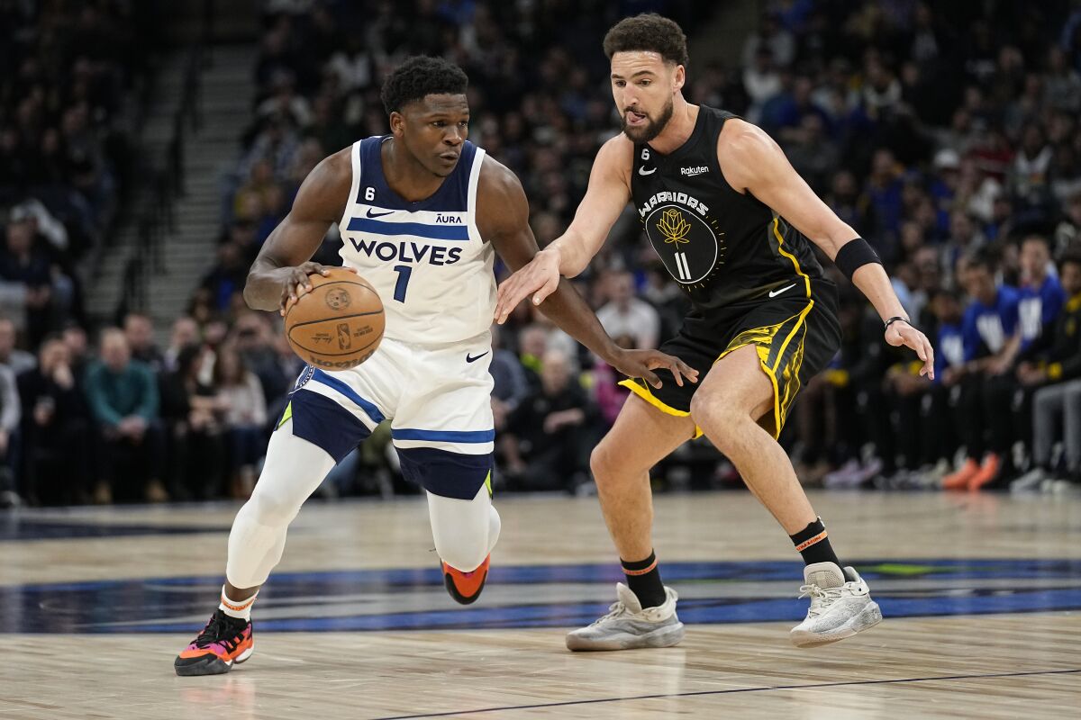 Minnesota Timberwolves guard Anthony Edwards (1) works towards the basket while defended by Golden State Warriors guard Klay Thompson (11) during the first half of an NBA basketball game, Wednesday, Feb. 1, 2023, in Minneapolis. (AP Photo/Abbie Parr)