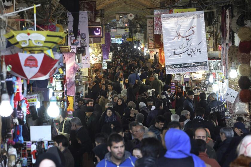 Iranians shop at Tehran's old main bazaar on Monday. As the West temporarily eases some economic sanctions against the country in exchange for restraints on nuclear development, the two sides are putting a different spin on how the ease-up will affect Iran's economy.