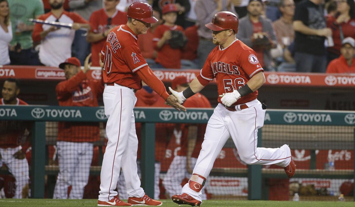 Angels' Kole Calhoun, right, celebrates his home run with third base coach Ron Roenicke during the third inning against the Minnesota Twins on Tuesday.